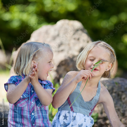 zwei kinder mit grashalm