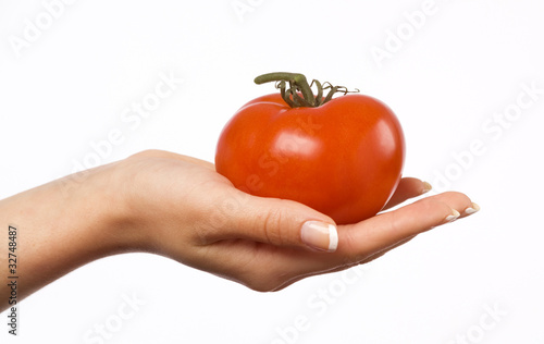 Woman's hand holding a red tomato