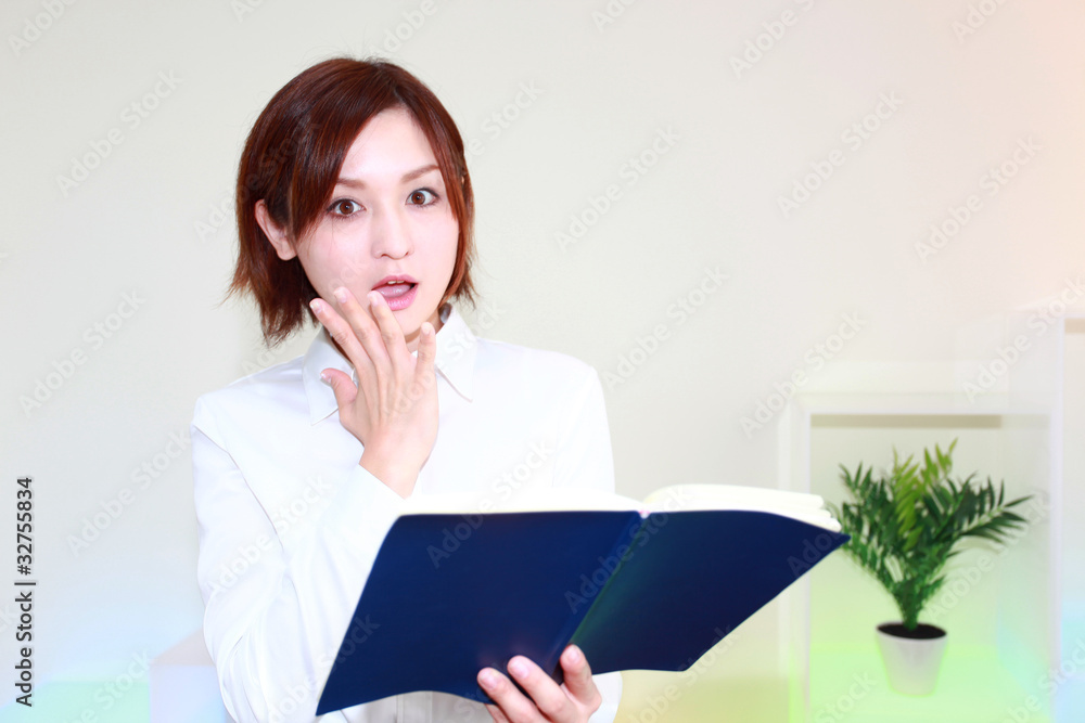 手帳を見てびっくりしているオフィスレディー