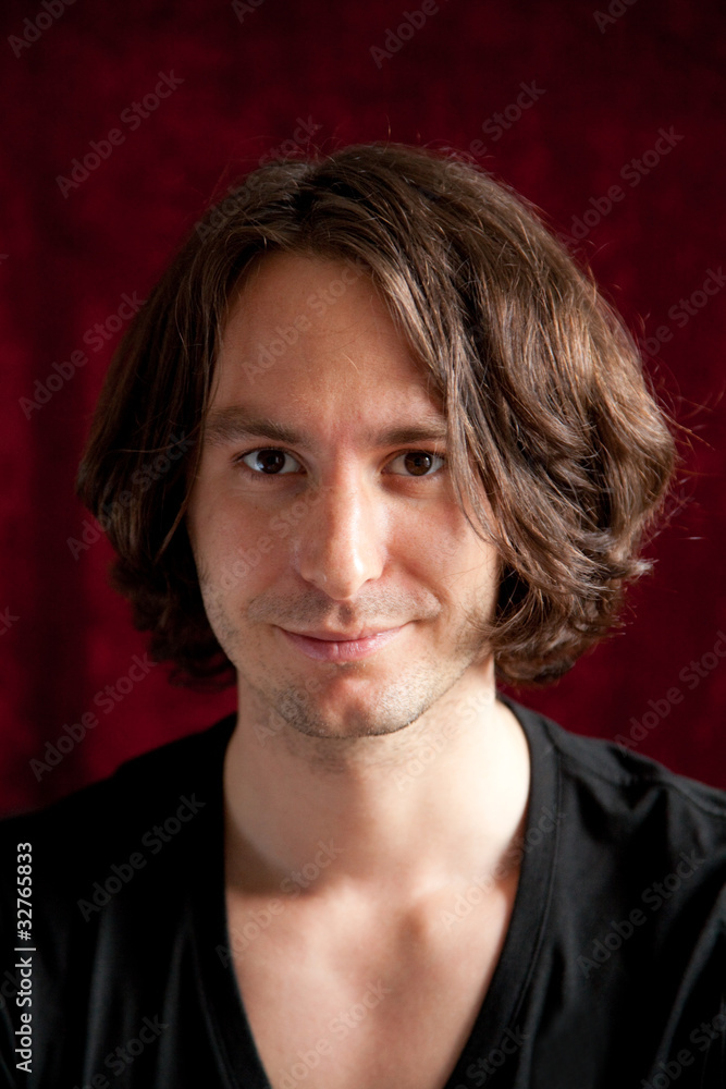 Fototapeta premium freundlicher blick eines jungen mannes mit langen haaren