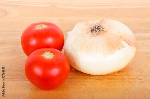Two Tomatoes and an Onion on a Wood Board