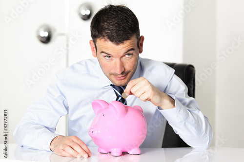 Tela young man with pink piggy bank and coin