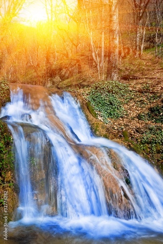 beautiful waterfall in a rays of sun