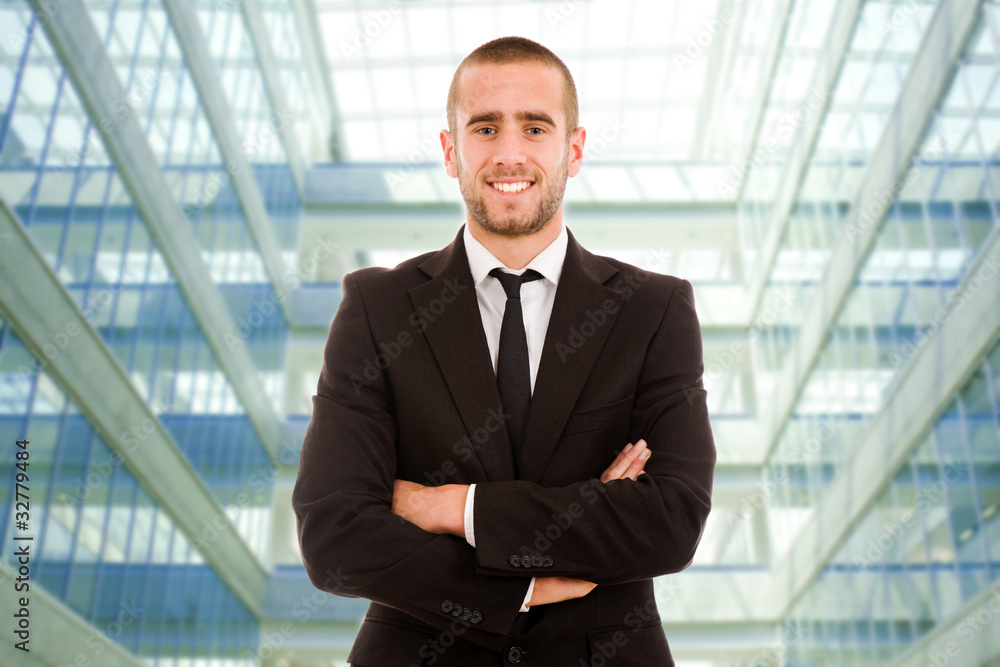 A smiling handsome young business man at a modern office buildin A smiling handsome young business man at a modern office buildin