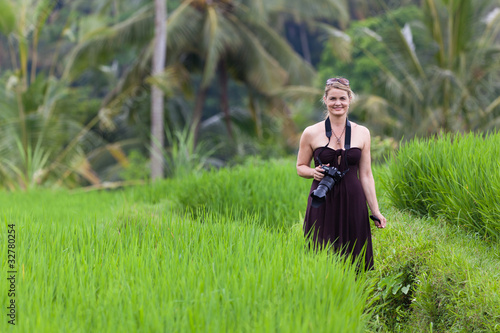 Smiling Woman with Camera in Bali Rice Field