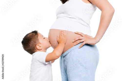 Kleinkind küßt schwangere Mutter