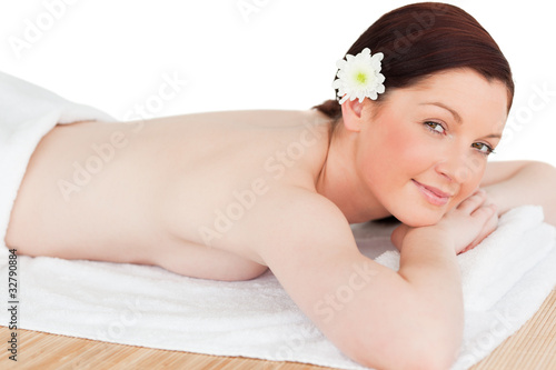 Portrait of a calm red-haired woman posing while relaxing in a s