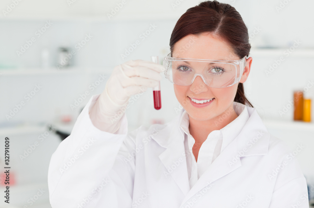 Gorgeous scientist looking at the camera while holding a test t Gorgeous scientist looking at the camera while holding a test t