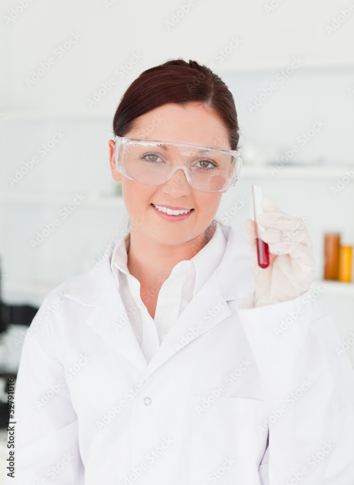 Smiling scientist looking at the camera while holding a test tu Smiling scientist looking at the camera while holding a test tu