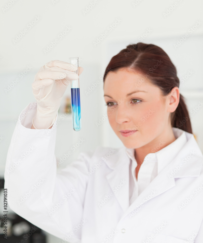 Beautiful red-haired scientist looking at the camera while holdi Beautiful red-haired scientist looking at the camera while holdi