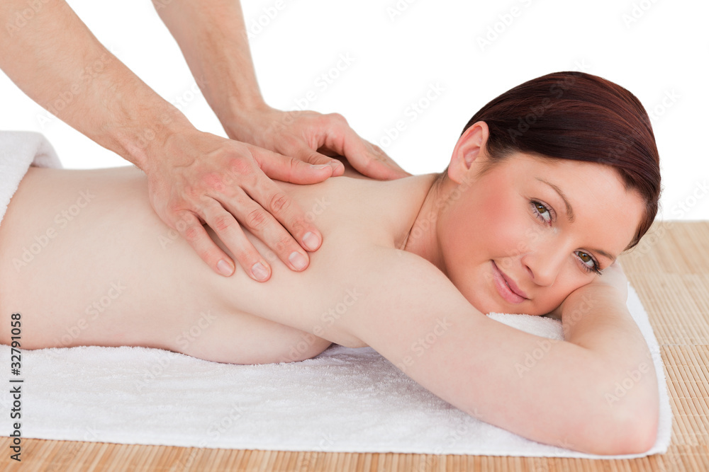 Closeup of a beautiful red-haired woman receiving a massage in a