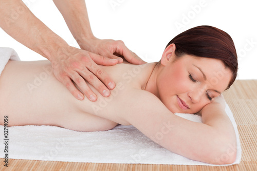 Closeup of a charming red-haired woman receiving a massage in a