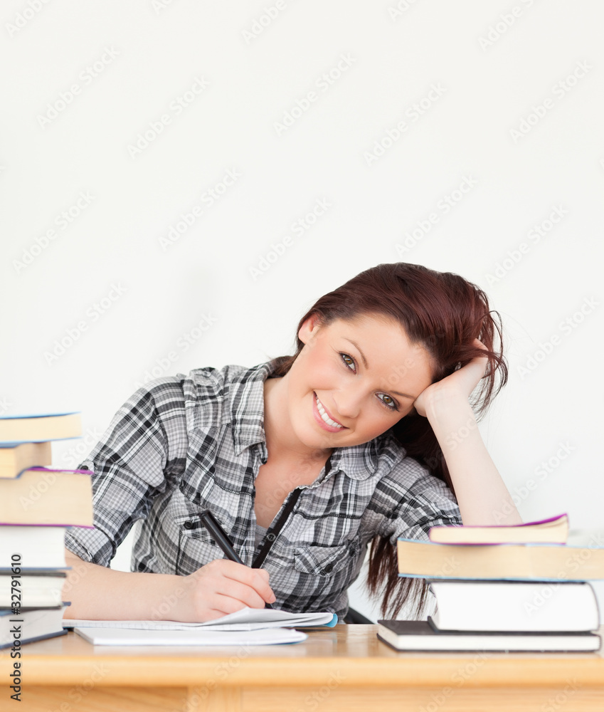 Attractive joyful red-haired girl studying for an examination Attractive joyful red-haired girl studying for an examination