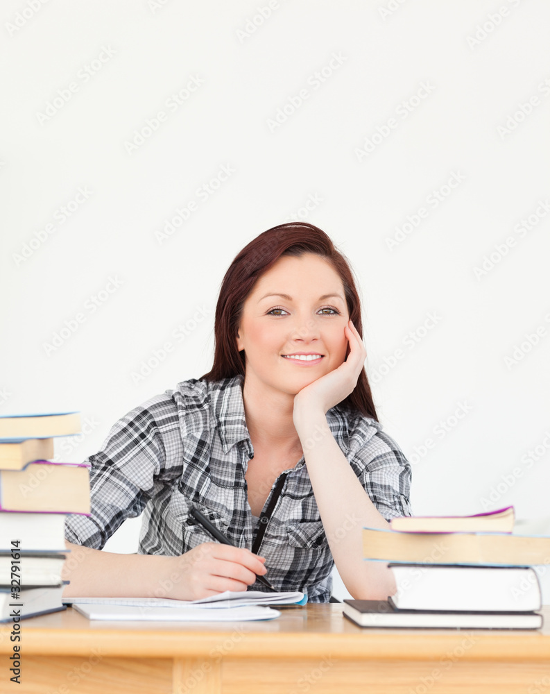 Beautiful joyful red-haired girl studying for an examination Beautiful joyful red-haired girl studying for an examination