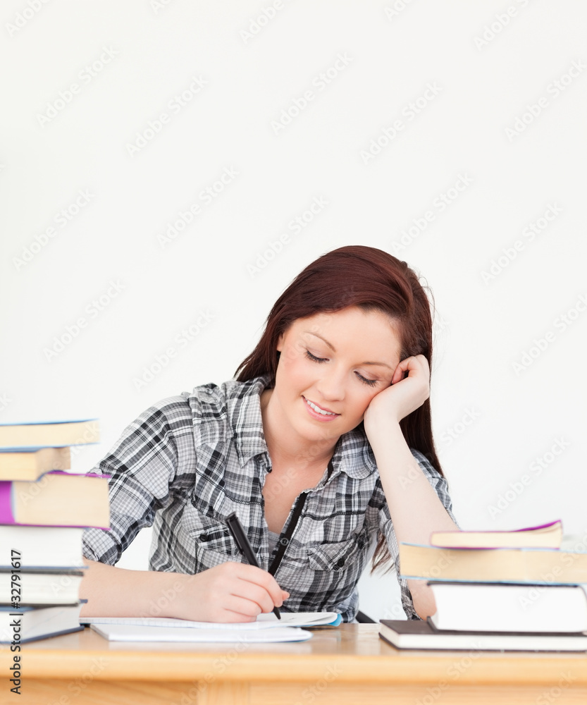 Attractive happy red-haired girl studying for an examination Attractive happy red-haired girl studying for an examination