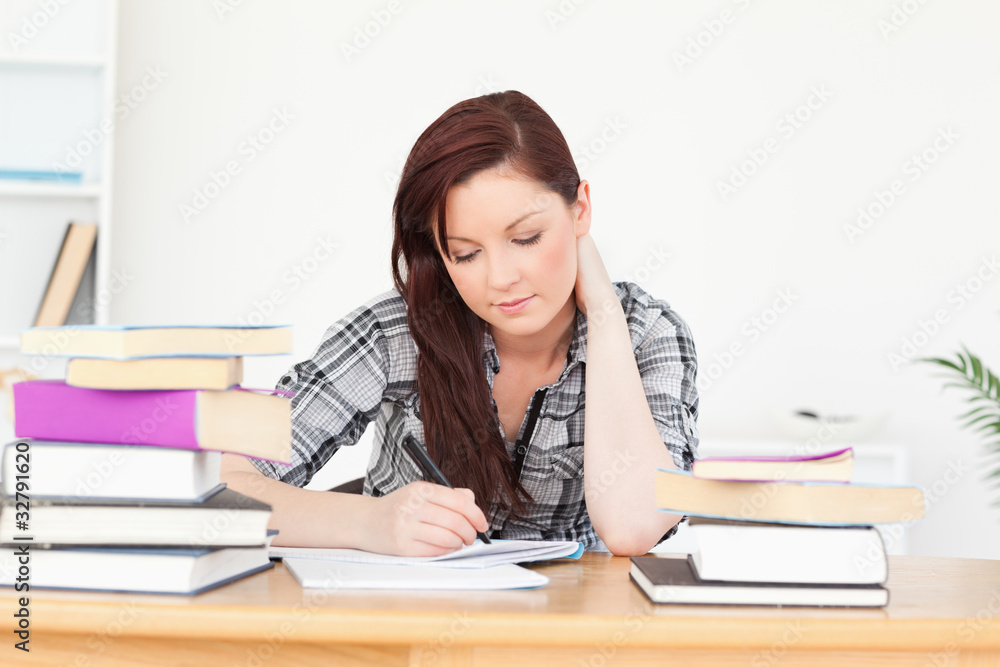 Beautiful happy red-haired girl studying for an examination Beautiful happy red-haired girl studying for an examination
