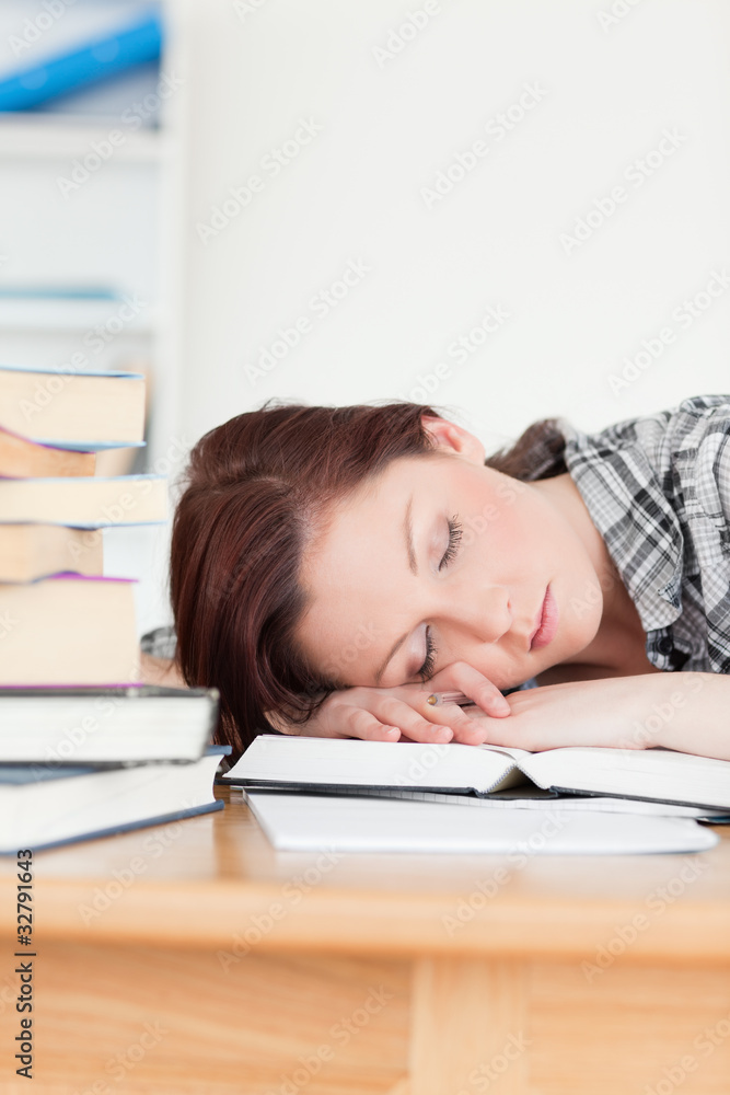 Attractive red-haired girl having a rest while studying for an e Attractive red-haired girl having a rest while studying for an e