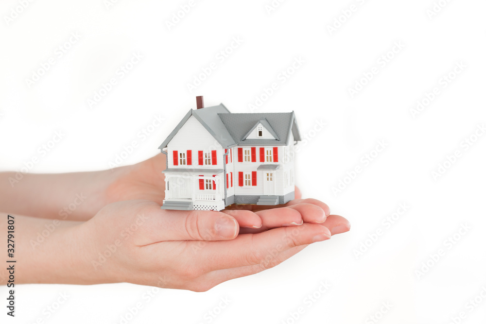Hands holding a miniature house on a white background Hands holding a miniature house on a white background