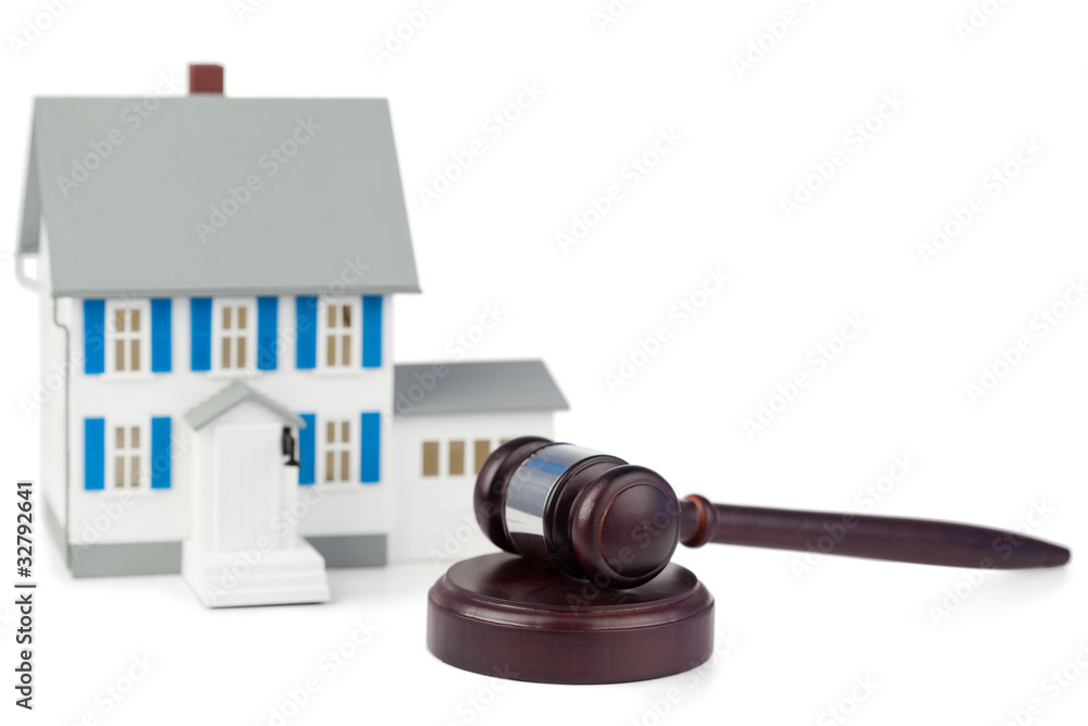 Grey toy house model and brown gavel Grey toy house model and brown gavel