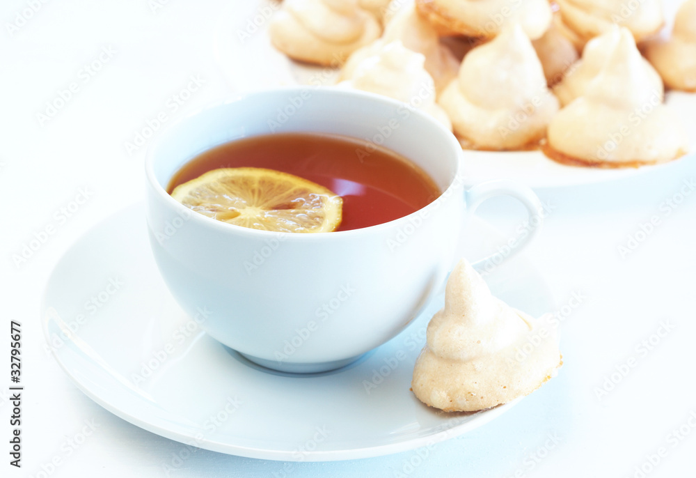 Cup of tea with lemon and meringue cookies Cup of tea with lemon and meringue cookies