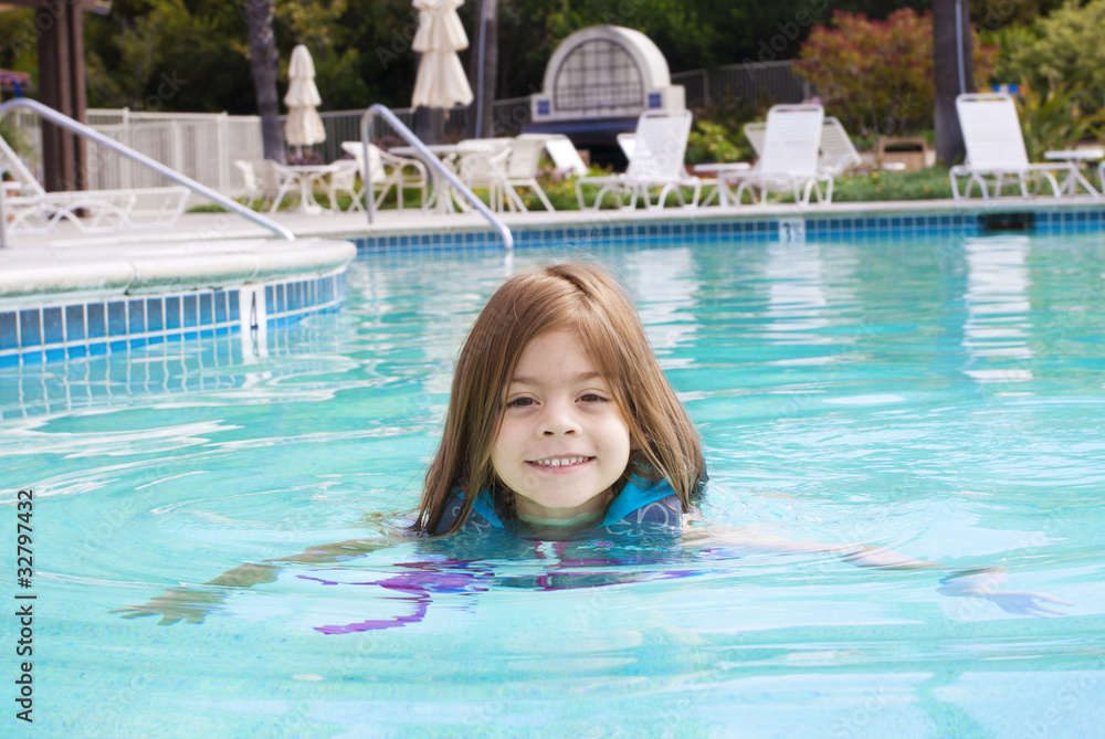 Cute Little Girl swimming in the Pool