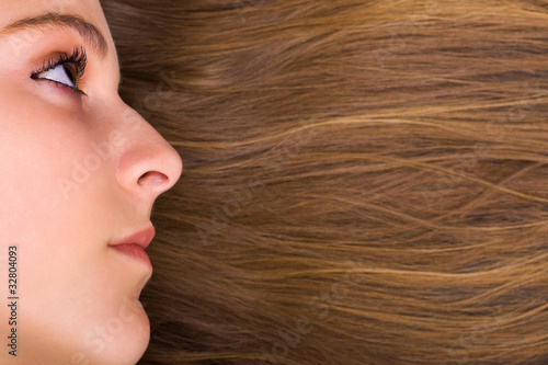 close-up of beautiful young female face with long beauty hair as