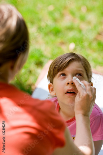 mother wiping daughter s eye with a tissue