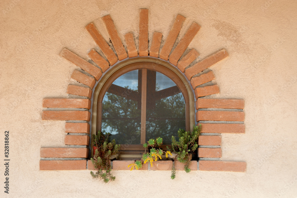 Foto Stock piccola finestra con cornice in mattoni | Adobe Stock