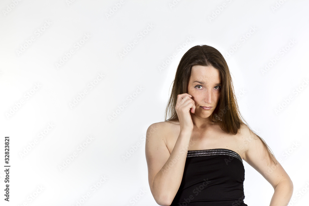 Junge Frau mit Hand an Wange schaut in Kamera Junge Frau mit Hand an Wange schaut in Kamera