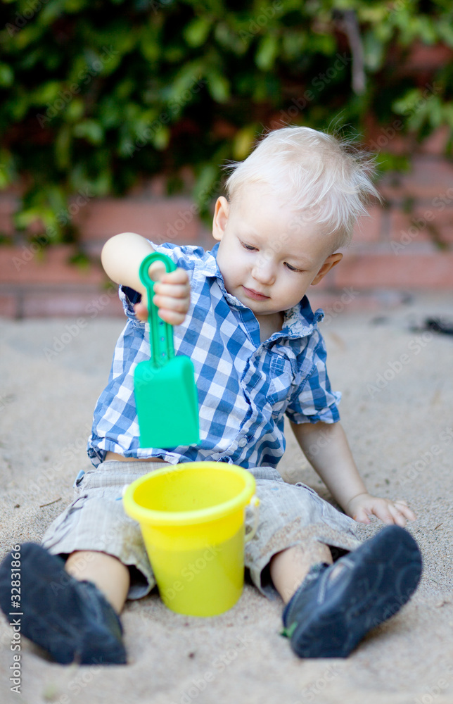 toddler playing in sandbox