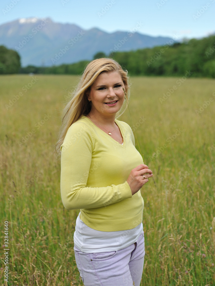 Pretty healthy summer woman outdoors on green field in Alps enjo Pretty healthy summer woman outdoors on green field in Alps enjo