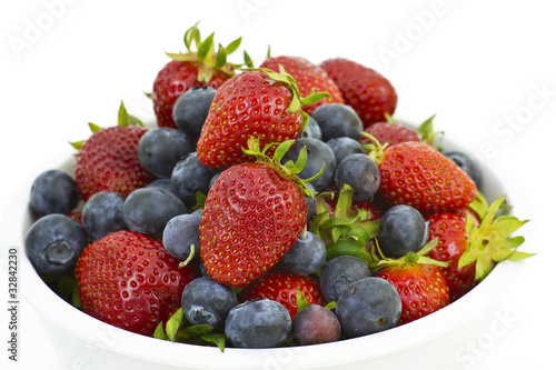 Strawberries and blueberries in a white bowl