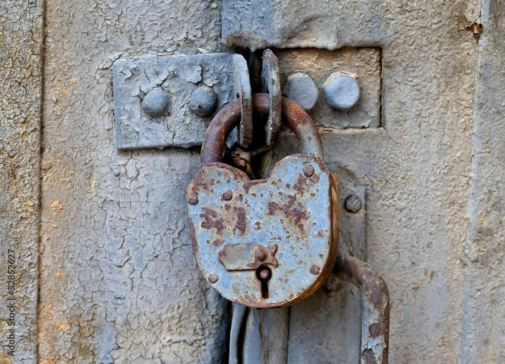 Rusty padlock on an old metal door Rusty padlock on an old metal door