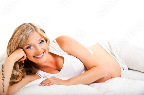 Pregnant woman in bed isolated on white