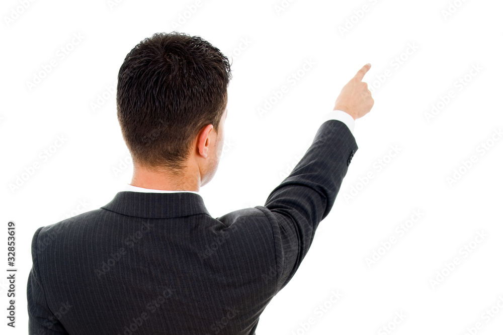 Back view of a young business man pointing at something over whi Back view of a young business man pointing at something over whi