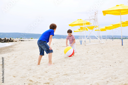 Two boys playing with ball on the beach