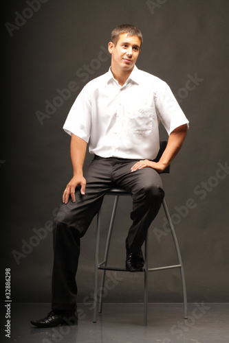 A man sits on a chair.