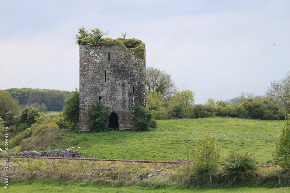 An old castle ruin with a railway line running in front of it