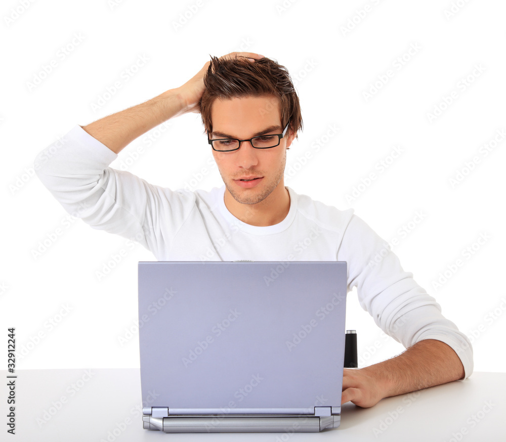 Junger Mann sitzt ratlos vor seinem Computer Stock-Foto | Adobe Stock