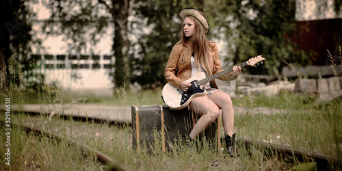 Mädchen mit Gitarre wartet auf Zug