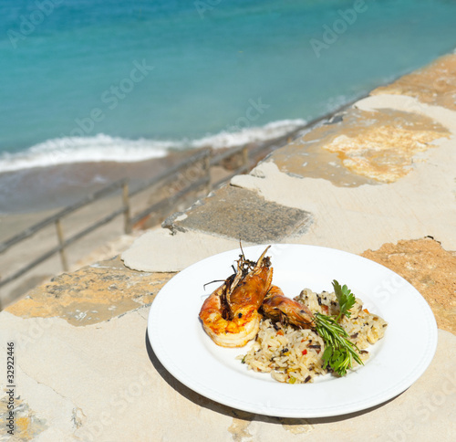 The dish with srimps and rice near mediterranean shore photo