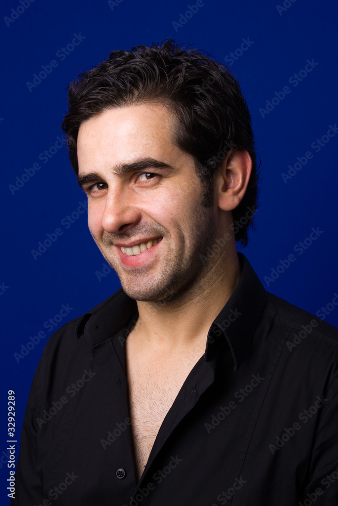 smiling handsome young man standing on blue background smiling handsome young man standing on blue background