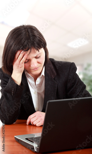 Woman having headache in the office and getting tired