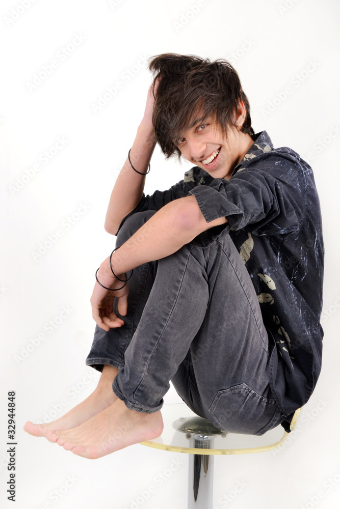 Jeune souriant sur un tabouret Jeune souriant sur un tabouret
