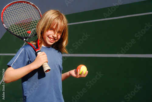 Enfant heureux s'entrainant au mur du tennis
