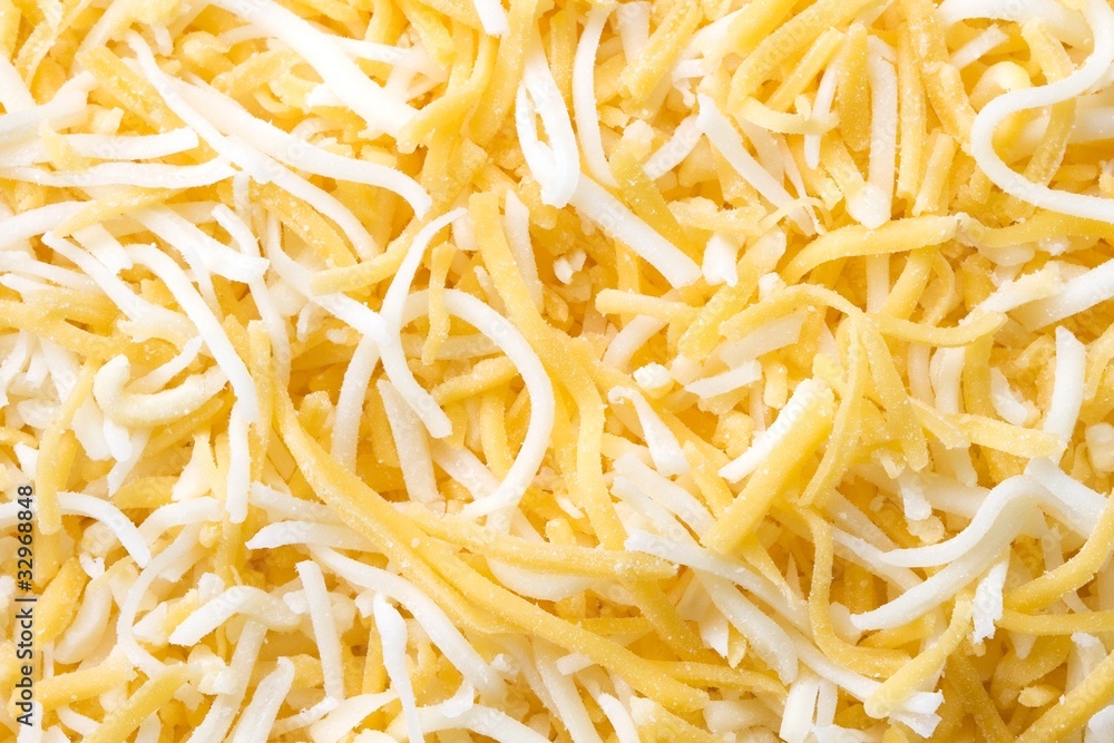 Shredded monterey jack and cheddar cheese closeup background Shredded monterey jack and cheddar cheese closeup background