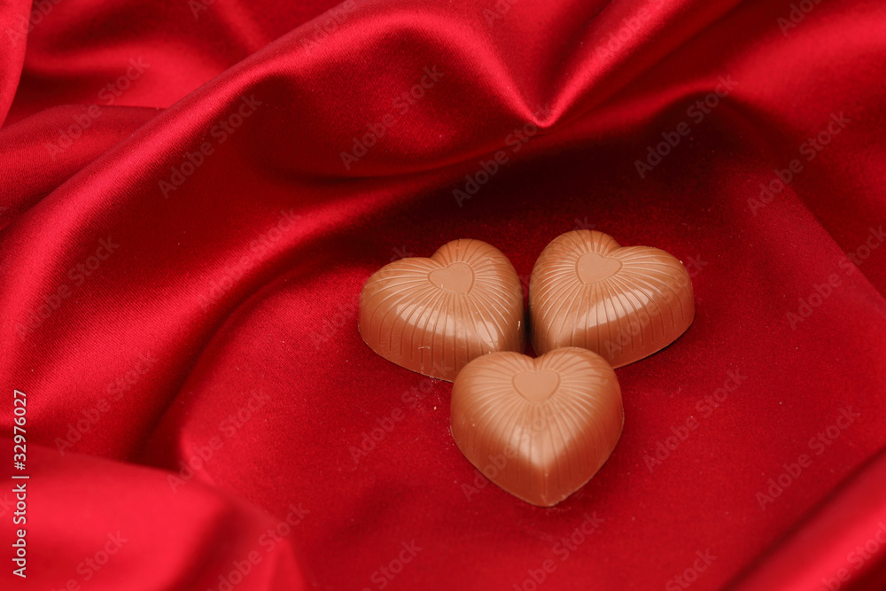 Fototapeta premium candy hearts on red satin