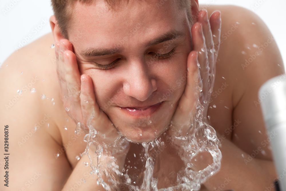 young man washing his face young man washing his face