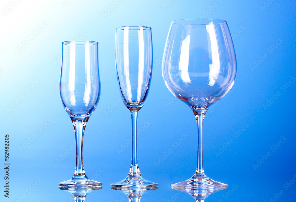 Few empty wine glasses on blue background Few empty wine glasses on blue background