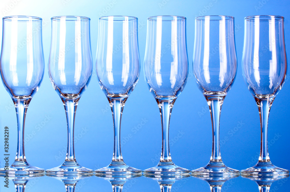 Few empty wine glasses on blue background Few empty wine glasses on blue background